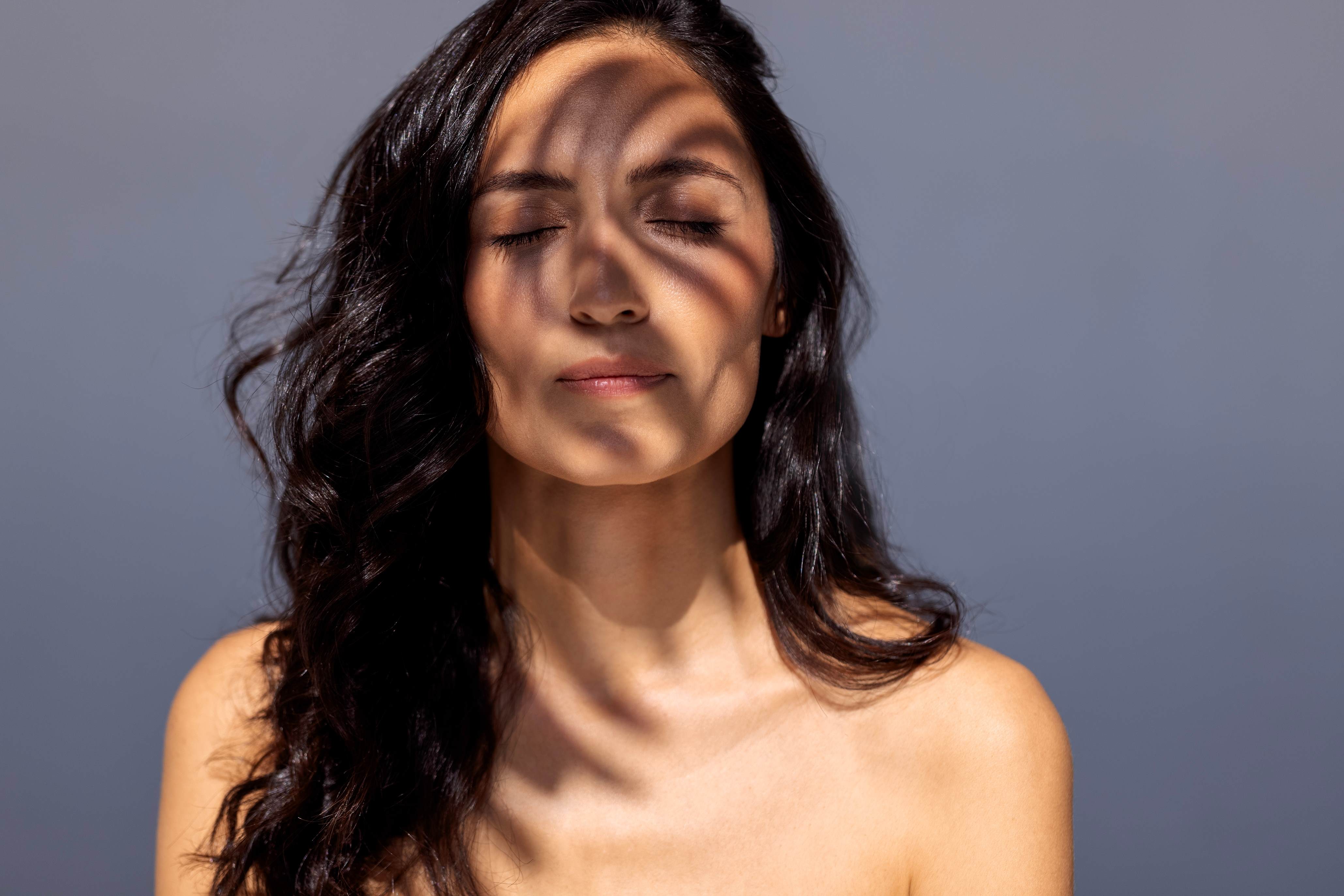 women in sun with leaf shaddowing