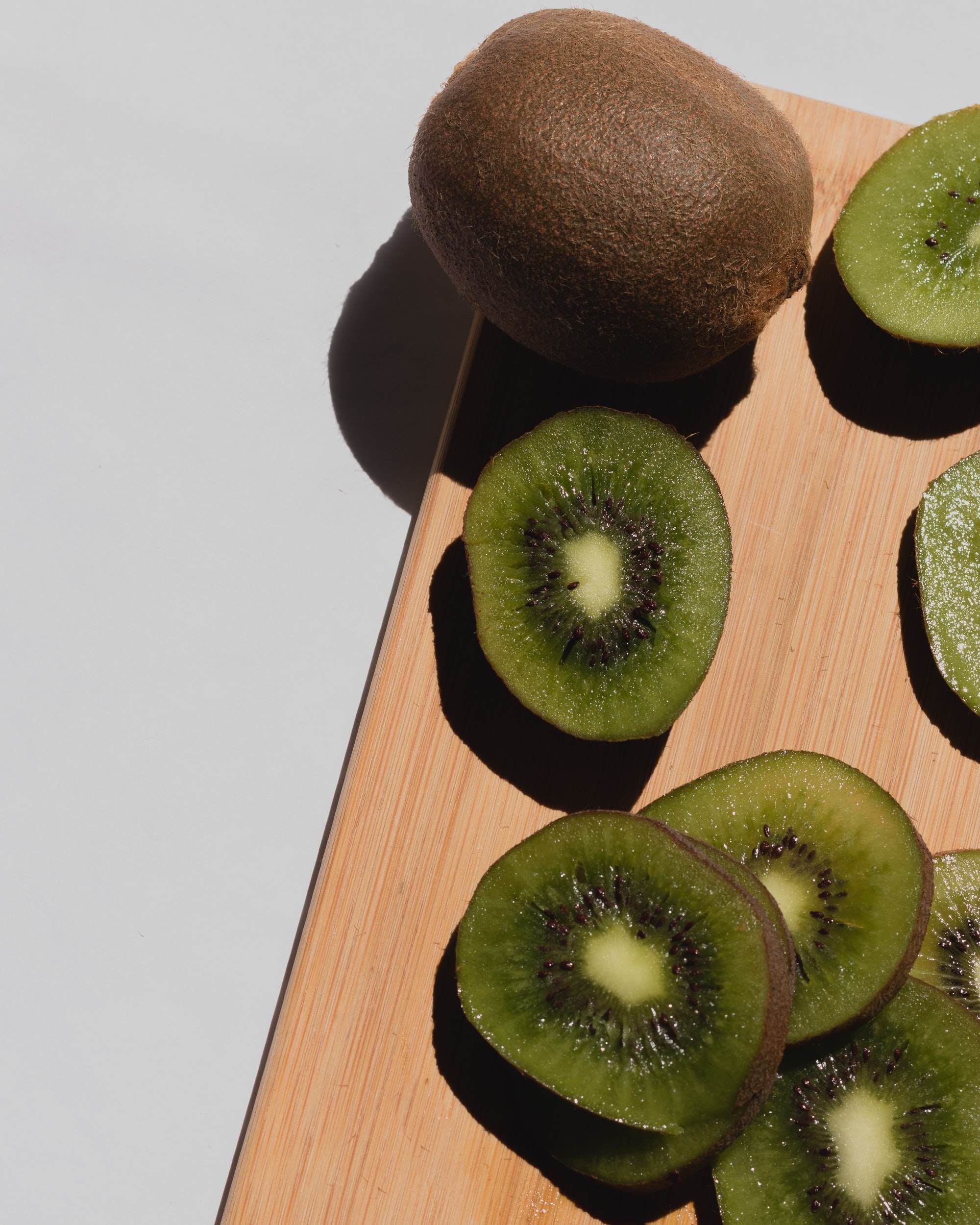 sliced kiwi on wooden board
